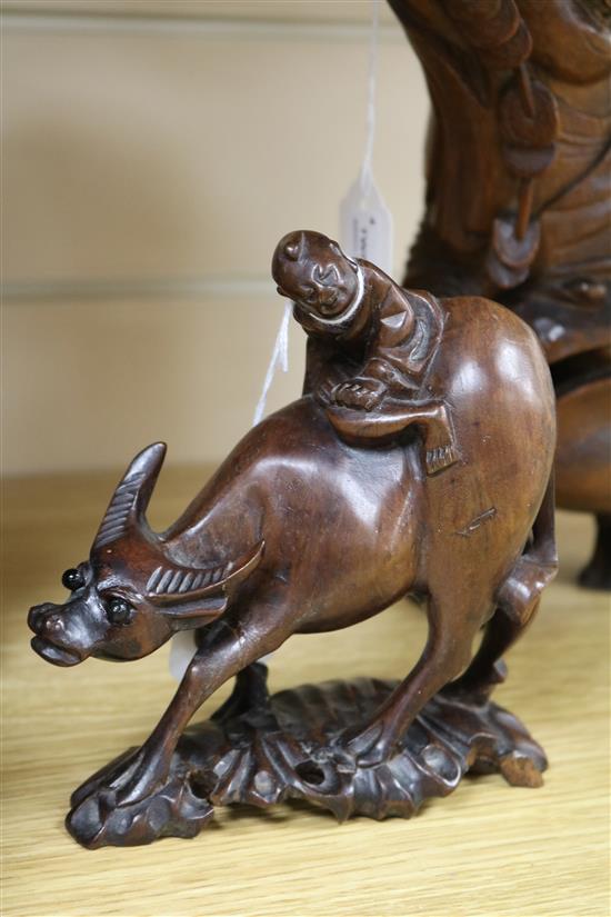 Three Chinese figural wood carvings and a soapstone carving of a child riding a water buffalo,